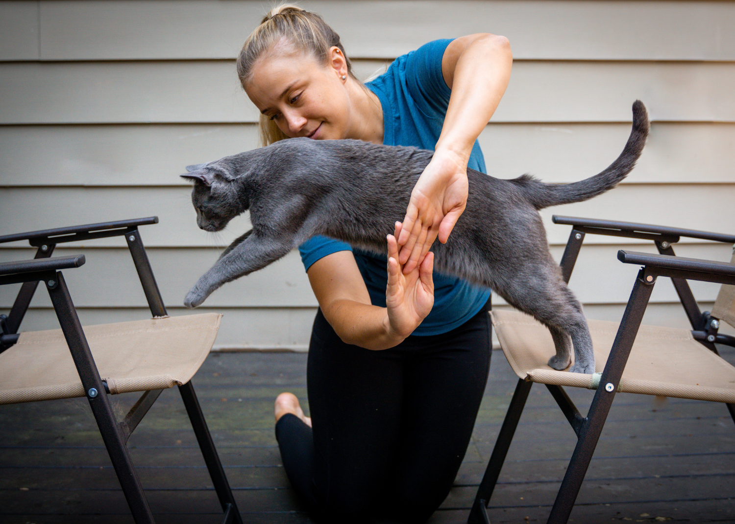 woman making circle with arms, cat jumping through - cat training